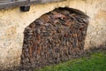 Slanted view of old roof tiles stored in a indentation of a old stone wall