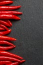 Slate background with red hot chilli peppers. Concept for chilli peppers lovers Royalty Free Stock Photo