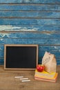 Slate, chalk, apple, lunch bag and books Royalty Free Stock Photo