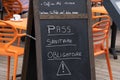 Slate in front of a restaurant with written on it in French `compulsory health pass`