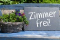 Slate on a garden bench with the german words for vacancies - zimmer frei