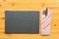 Slate place mat with knife and fork in folded napkin