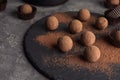 Slate plate with chocolate truffles on grey background Royalty Free Stock Photo