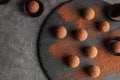 Slate plate with chocolate truffles on grey background, top view. Royalty Free Stock Photo