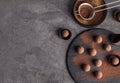 Slate plate with chocolate truffles on grey background, top view. Royalty Free Stock Photo