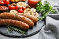 Slate plate with delicious sausages and vegetables served for barbecue party Royalty Free Stock Photo