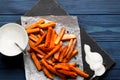 Slate plate with deliciously cooked sweet potatoes, rosemary, sauce and spices, herbs on a wooden Royalty Free Stock Photo