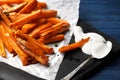 Slate plate with deliciously cooked sweet potatoes, rosemary, sauce and spices, herbs on a wooden Royalty Free Stock Photo