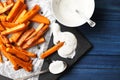 Slate plate with deliciously cooked sweet potatoes, rosemary, sauce and spices, herbs on a wooden Royalty Free Stock Photo