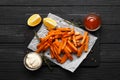 Slate plate with deliciously cooked sweet potatoes, rosemary, sauce and spices, herbs on a wooden Royalty Free Stock Photo