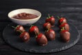 Slate plate with chocolate covered strawberries on table Royalty Free Stock Photo