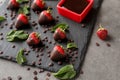 Slate plate with tasty chocolate dipped strawberries on grey table Royalty Free Stock Photo
