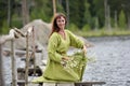 Woman by the water with a wreath in her hands Royalty Free Stock Photo