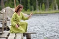 Woman by the water with a wreath in her hands Royalty Free Stock Photo