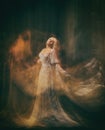 Slave, servant of darkness ... Queen albino. A blonde girl, like a ghost, in a white vintage dress, in a black room, a Royalty Free Stock Photo