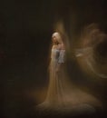 Slave, servant of darkness ... Queen albino. A blonde girl, like a ghost, in a white vintage dress, in a black room, a Royalty Free Stock Photo