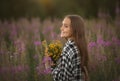 Slavian girl with wild flowers on the field