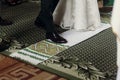 Slavic traditional wedding ceremony, stylish bride and groom stepping onto white towel during coronation, christian church wedding