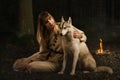 Slavonian girl and siberian husky in the deep forest