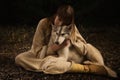 Slavonian girl and siberian husky in the deep forest