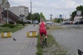 A young woman with a yellow mountain bike is riding along the sidewalk. A walk on a bicycle in the park. Girl with Royalty Free Stock Photo