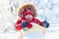 Sled and snow fun for kids. Baby sledding in winter park. Royalty Free Stock Photo