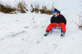 For a sledge down the boy in red pants is very happy Royalty Free Stock Photo