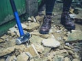 Sledge hammer outside by person's feet