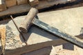 A sledgehammer or hammer made by workers licks on a concrete block at a construction site. Working tool close-up