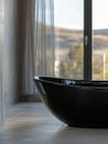 Sleek black bathtub in a modern, spacious bathroom. Royalty Free Stock Photo