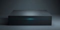 A sleek, black box with a glowing blue line on its surface sits in an otherwise dark room Royalty Free Stock Photo