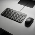 A sleek black computer keyboard and mouse set on a light gray desk Royalty Free Stock Photo