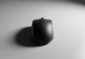 A sleek, black computer mouse is centered on a smooth, gray Royalty Free Stock Photo