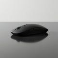 A sleek, black computer mouse with a streamlined design on a reflective surface. The Royalty Free Stock Photo