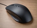 Sleek Black Computer Mouse on Wooden Surface for Modern Office and Gaming Use Royalty Free Stock Photo