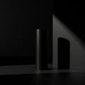 A sleek black cylindrical object stands on a matte black surface. Its smooth texture and minimalisti Royalty Free Stock Photo