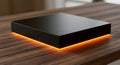 A sleek, black rectangular electronic device with a glowing orange LED strip Royalty Free Stock Photo