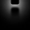 A sleek, black rectangular object hovers in a dark, minimalist setting. The object has smooth Royalty Free Stock Photo