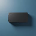 A sleek, black, rectangular object sits on a smooth blue surface. The object has a Royalty Free Stock Photo