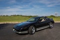 Sleek black and silver sports car with a vibrant blue mural design on the hood