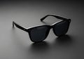 Sleek black sunglasses with a classic design sit on a smooth, dark surfac Royalty Free Stock Photo