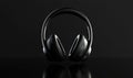 Sleek black wireless headphones on dark reflective surface showcasing modern design Royalty Free Stock Photo