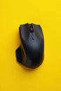 Sleek black wireless mouse, vibrant yellow backdrop , bright, bluetooth Royalty Free Stock Photo