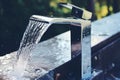 Sleek chrome bathroom faucet and fitting close up with water droplets for modern design Royalty Free Stock Photo