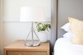 sleek chrome bedside lamp with white shade on nightstand