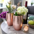 Sleek copper tumblers with hammered texture on marble surface