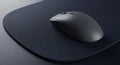 A sleek dark computer mouse rests on a dark textured mousepad creating a modern workspace aesthetic Royalty Free Stock Photo