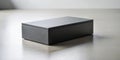 A sleek, dark gray rectangular box rests on a light gray surface, casting a subtle shadow, ideal for product presentation or Royalty Free Stock Photo