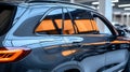 Sleek dark grey SUV parked in a modern garage, reflecting orange light Royalty Free Stock Photo