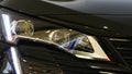 Sleek elegant headlight of modern french compact crossover SUV car Peugeot 5008, black colour